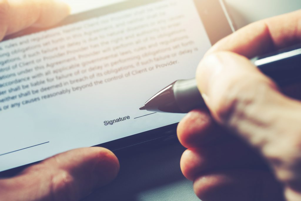 Man signing contract with digital pen on mobile phone