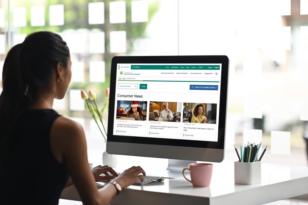 Woman reading ComReg consumer news on computer at home.