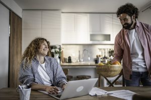 Couple checking broadband availability on laptop at home on ComReg's Broadband Checker